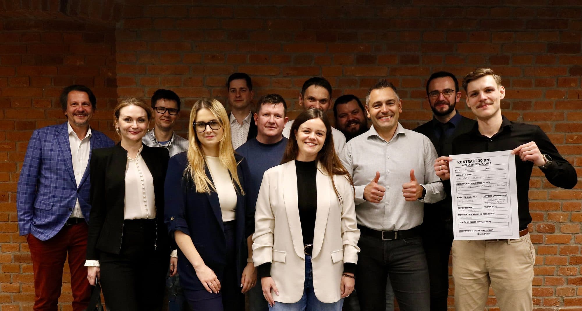 Grupa uczestników POST-CI LAB trzyma podpisany dokument Kontrakt 30 Dni